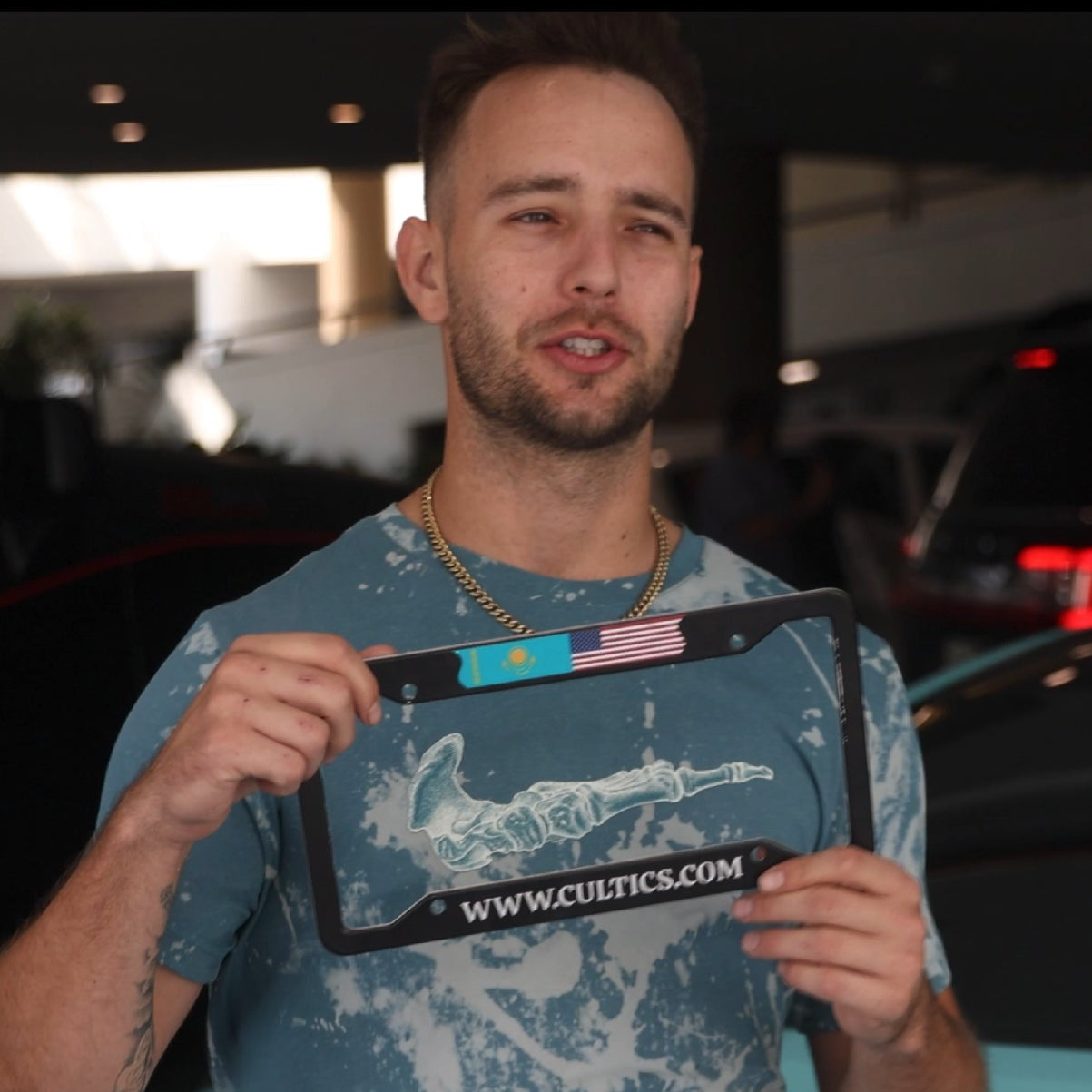 Cameron Clayton holding license plate frame with USA and Kazakhstan flag
